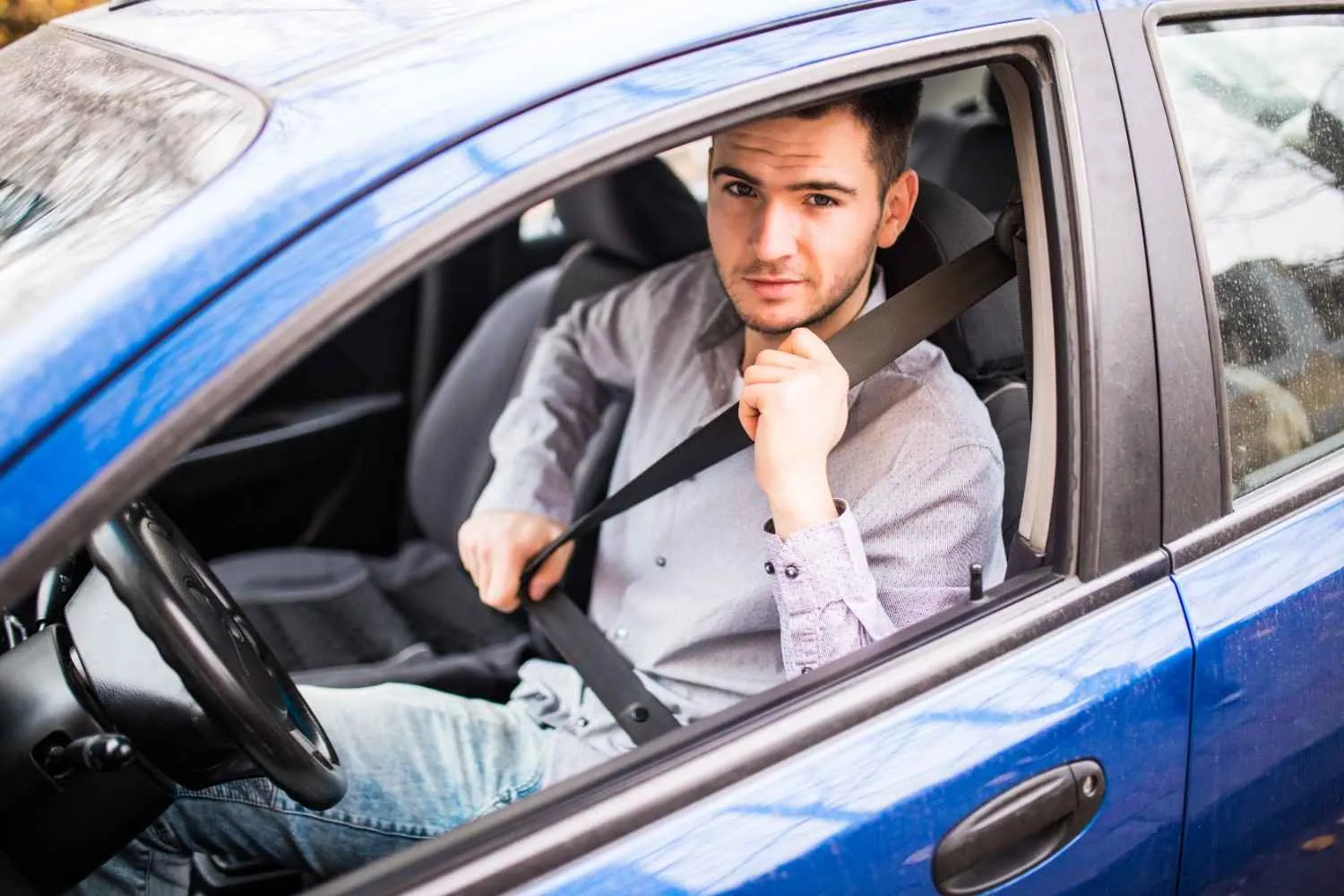 Smiling driver leaning out of a car window